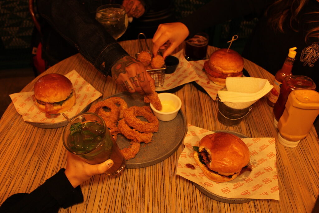 Amigos disfruando de hamburguesas gourmet en cdmx, en Monumental Burger.