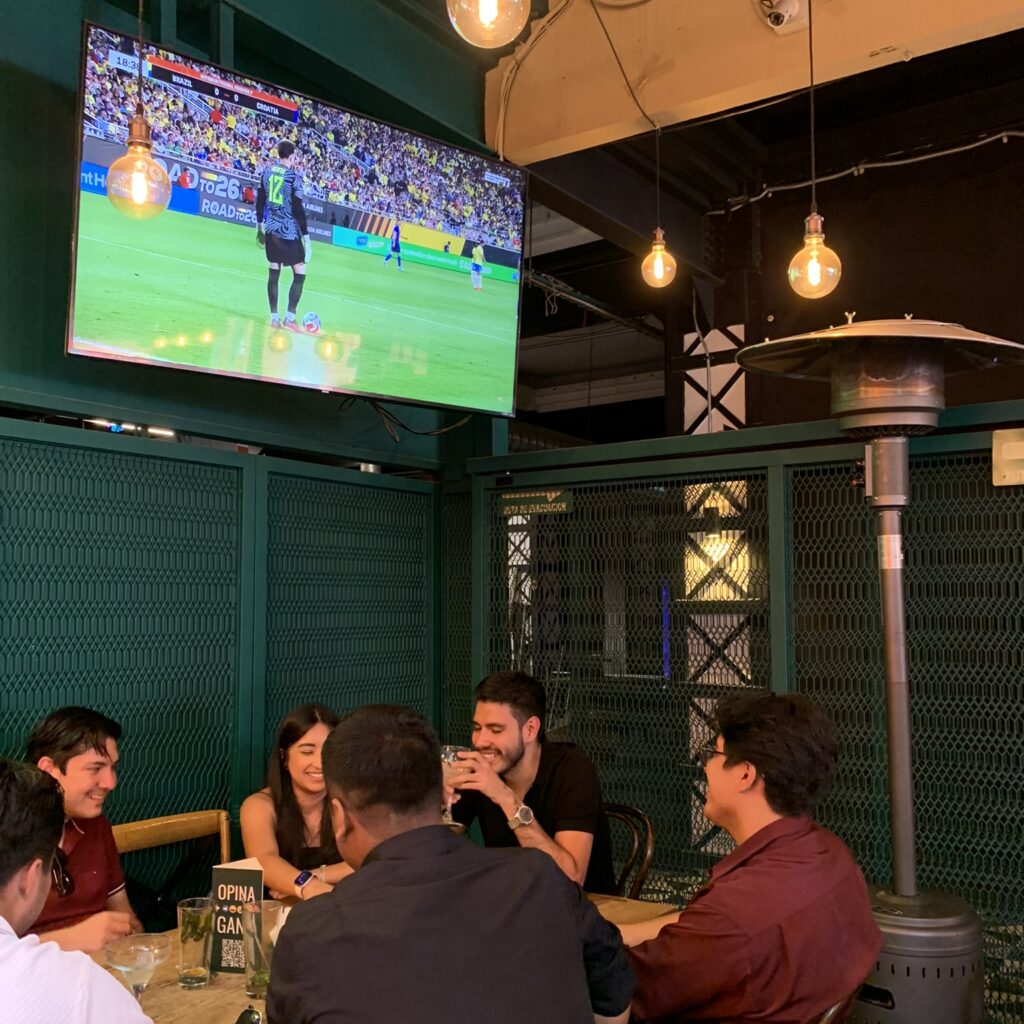Restaurantes para ver el fútbol en CDMX con amigos disfrutando hamburguesas y pantallas grandes durante el partido